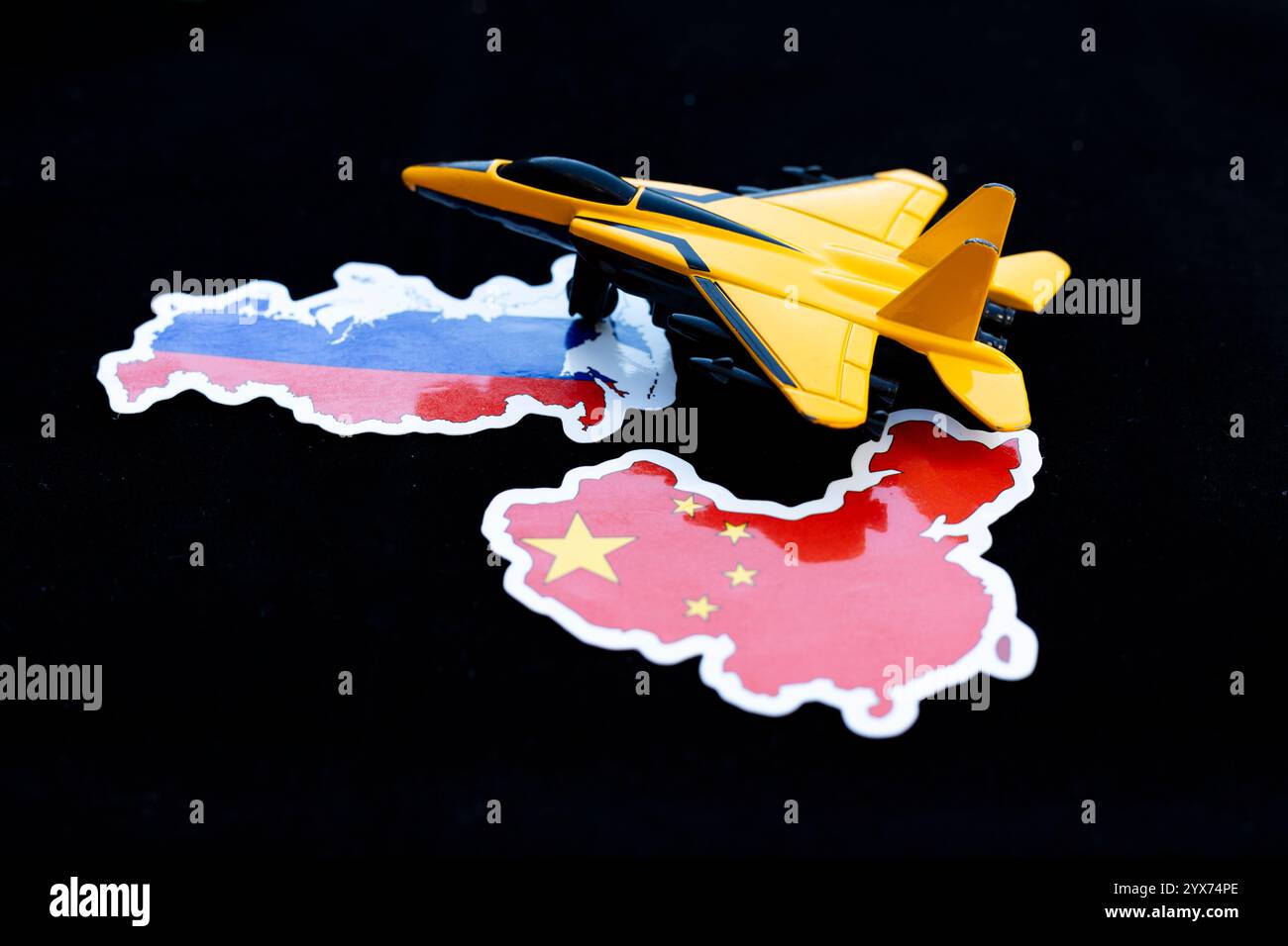 Caccia giocattolo giallo Jet on mappe di Russia e Cina. Concetto di alleanza militare. Foto Stock