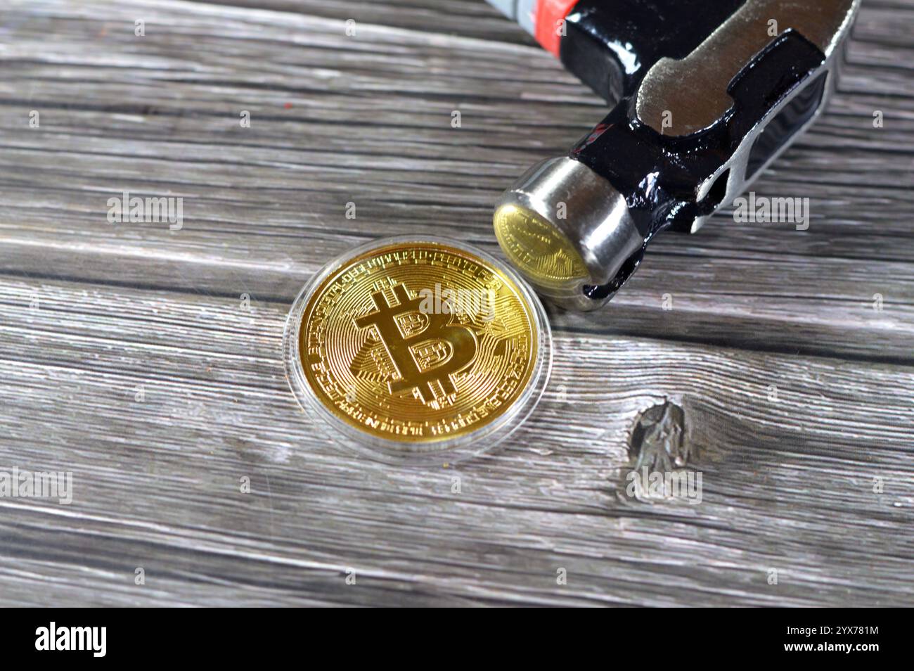 Un martello e un bitcoin d'oro fisico, BTC la prima criptovaluta decentralizzata, la valuta digitale del bitcoin si blocca, la diminuzione del valore e la caduta di BTC ma Foto Stock