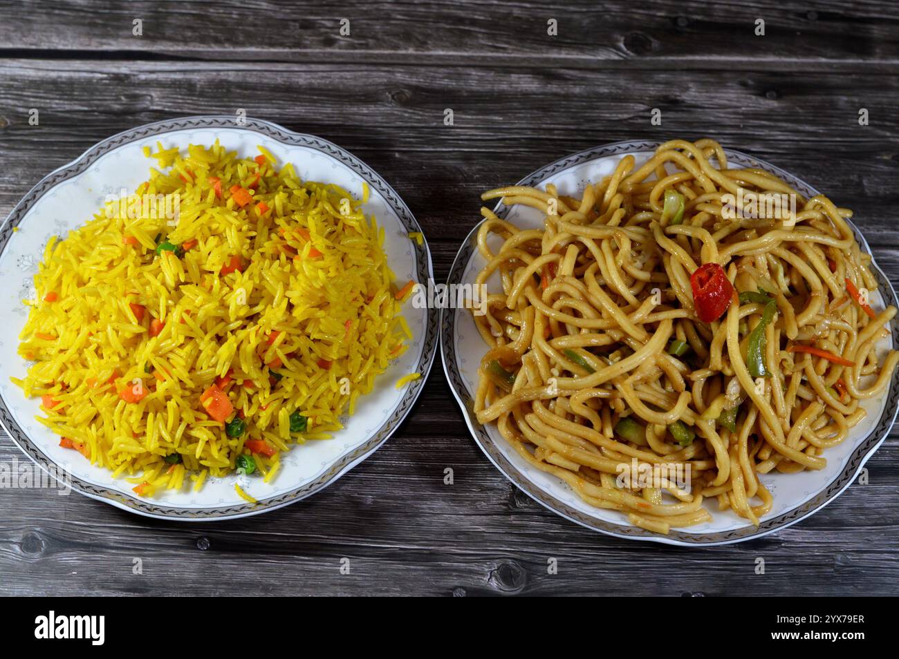 Spaghetti e riso sulla cucina asiatica, cibo cinese, riso Basmati giallo a grani lunghi con verdure, carote e piselli e spaghetti cinesi con cipolle e S. Foto Stock