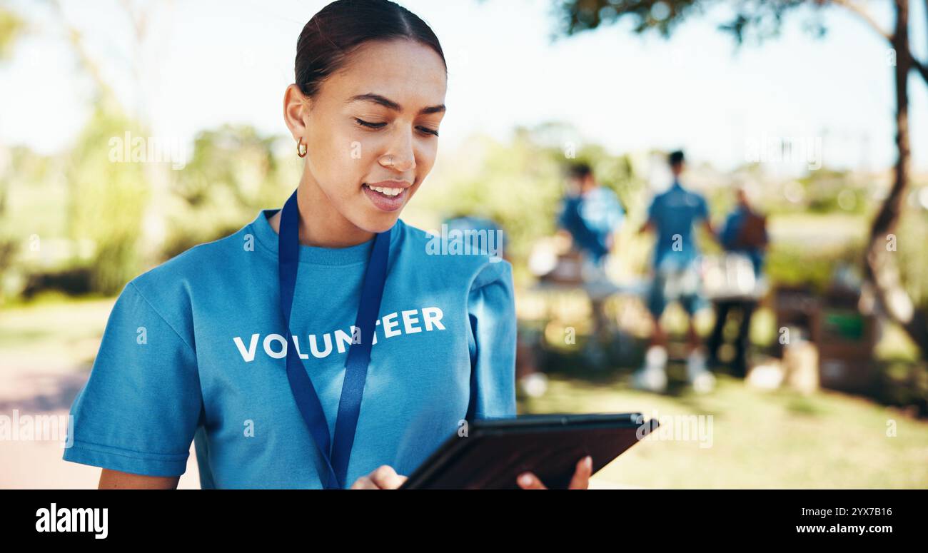 Associazione benefica, checklist e tablet con donna volontaria all'aperto nel parco per un'iniziativa alimentare comunitaria o una donazione. Attivismo, ricerca e società felici Foto Stock