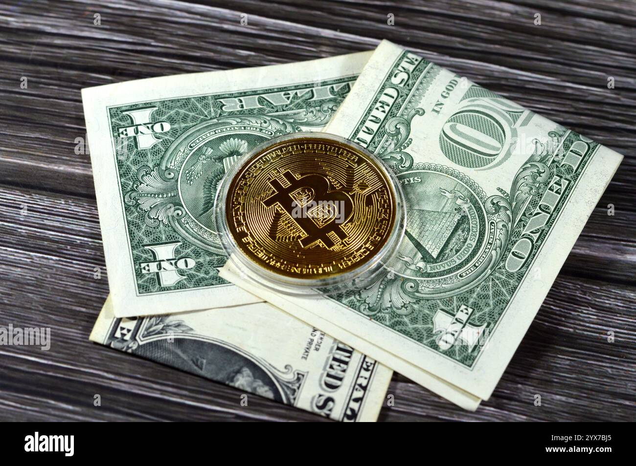 Banconota in dollari americani con moneta d'oro fisica Bitcoin, BTC la prima criptovaluta decentralizzata, nodi nella rete bitcoin P2P verificano la transazione Foto Stock