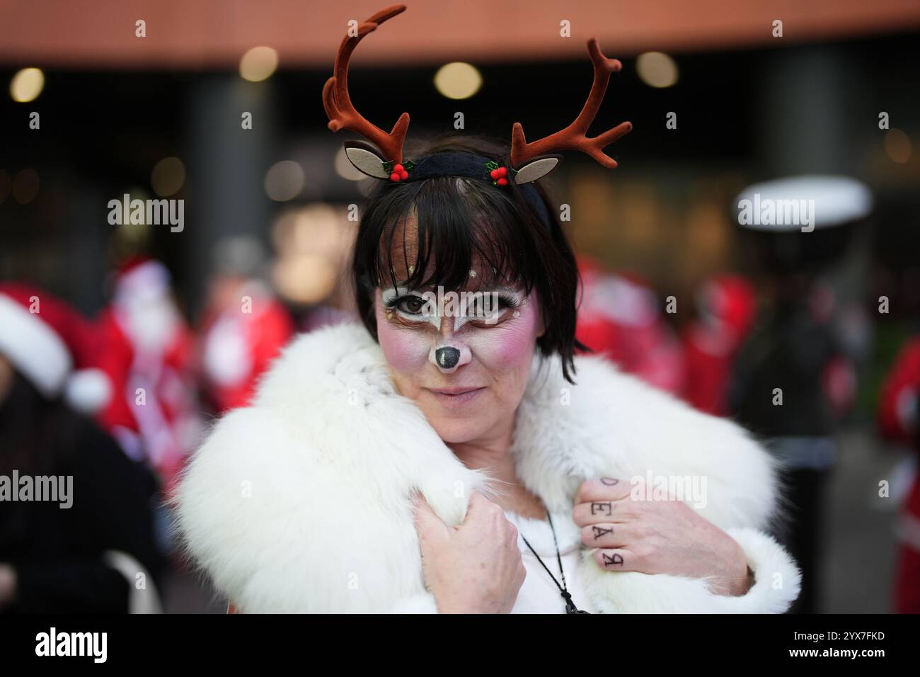 Una persona vestita da Babbo Natale prima di prendere parte alla parata natalizia di London Santacon al Floating Pocket Park di Londra. Data foto: Sabato 14 dicembre 2024. Foto Stock