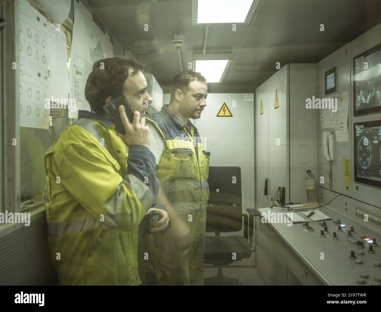 Operai in una sala di controllo della trivellatrice a doppio scudo nella sezione H53 della galleria di base del Brennero, Tirolo, Austria, Europa Foto Stock