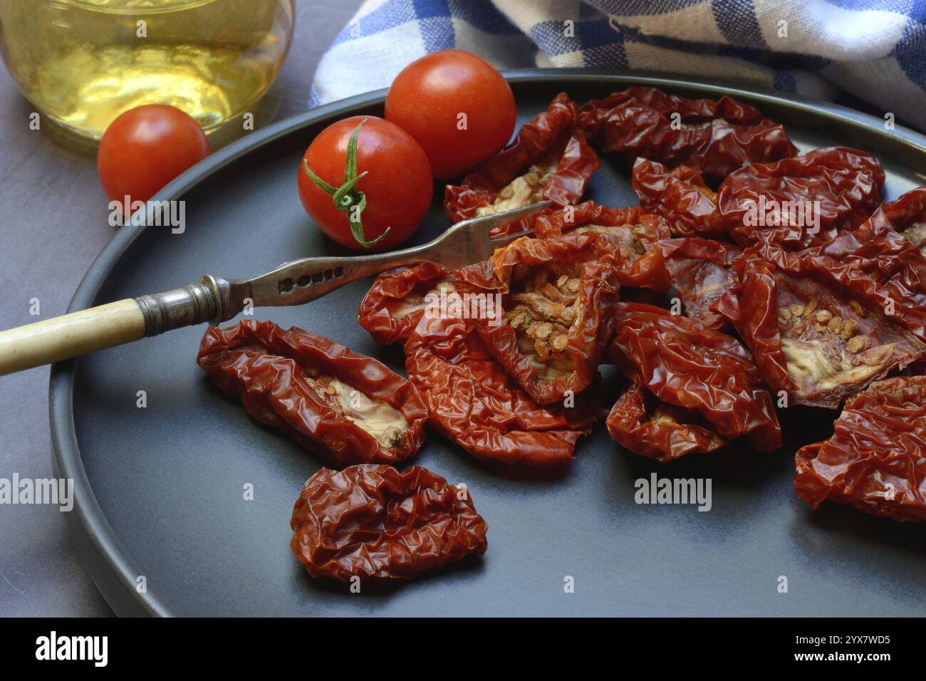 Pomodori secchi su piatto con forchetta, Solanum lycopersicum Foto Stock