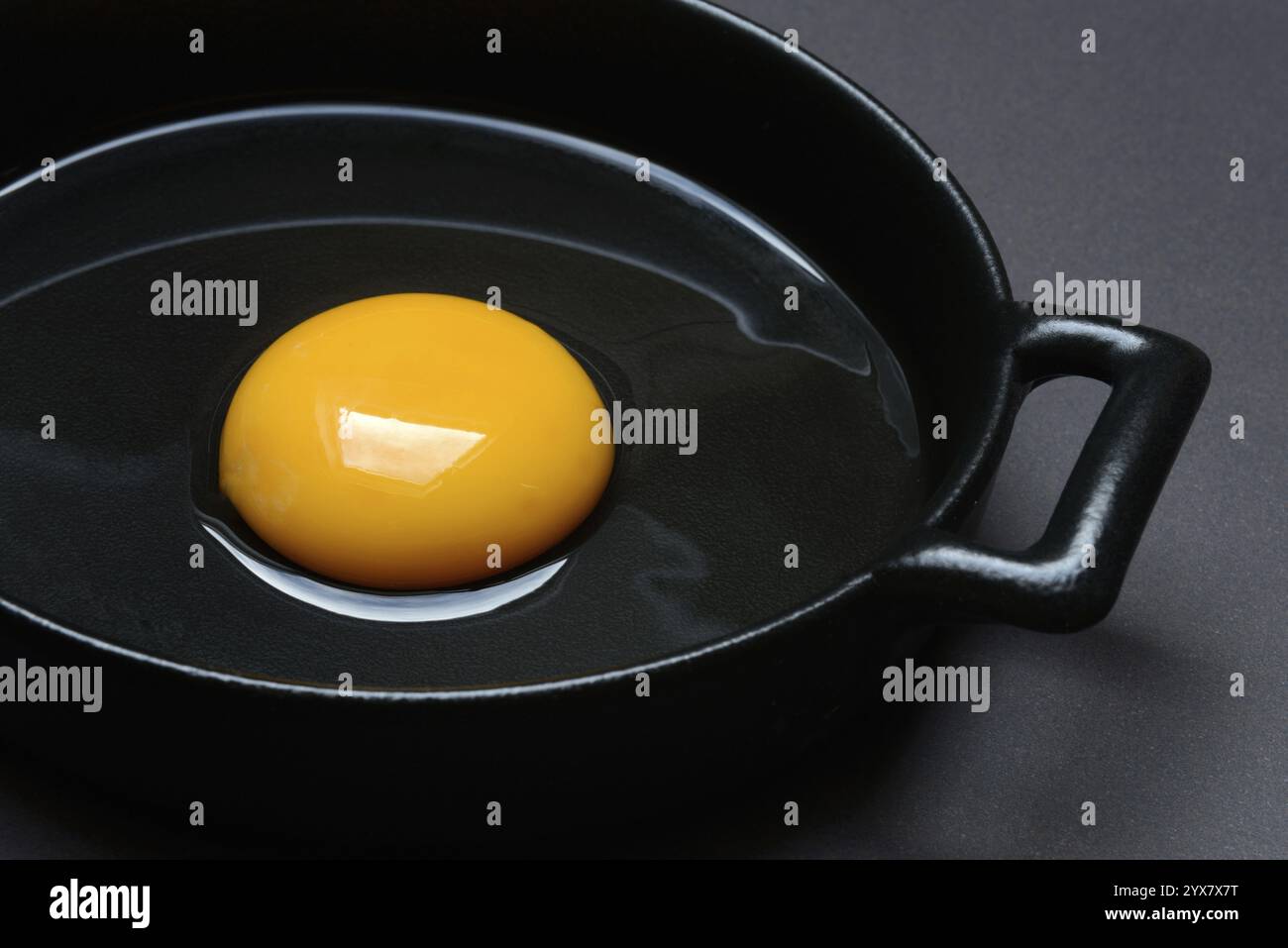 L'uovo si rompe in una padella, l'uovo di gallina Foto Stock