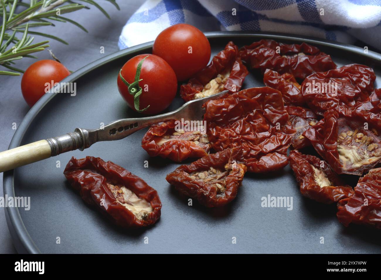 Pomodori secchi su piatto con forchetta, Solanum lycopersicum Foto Stock