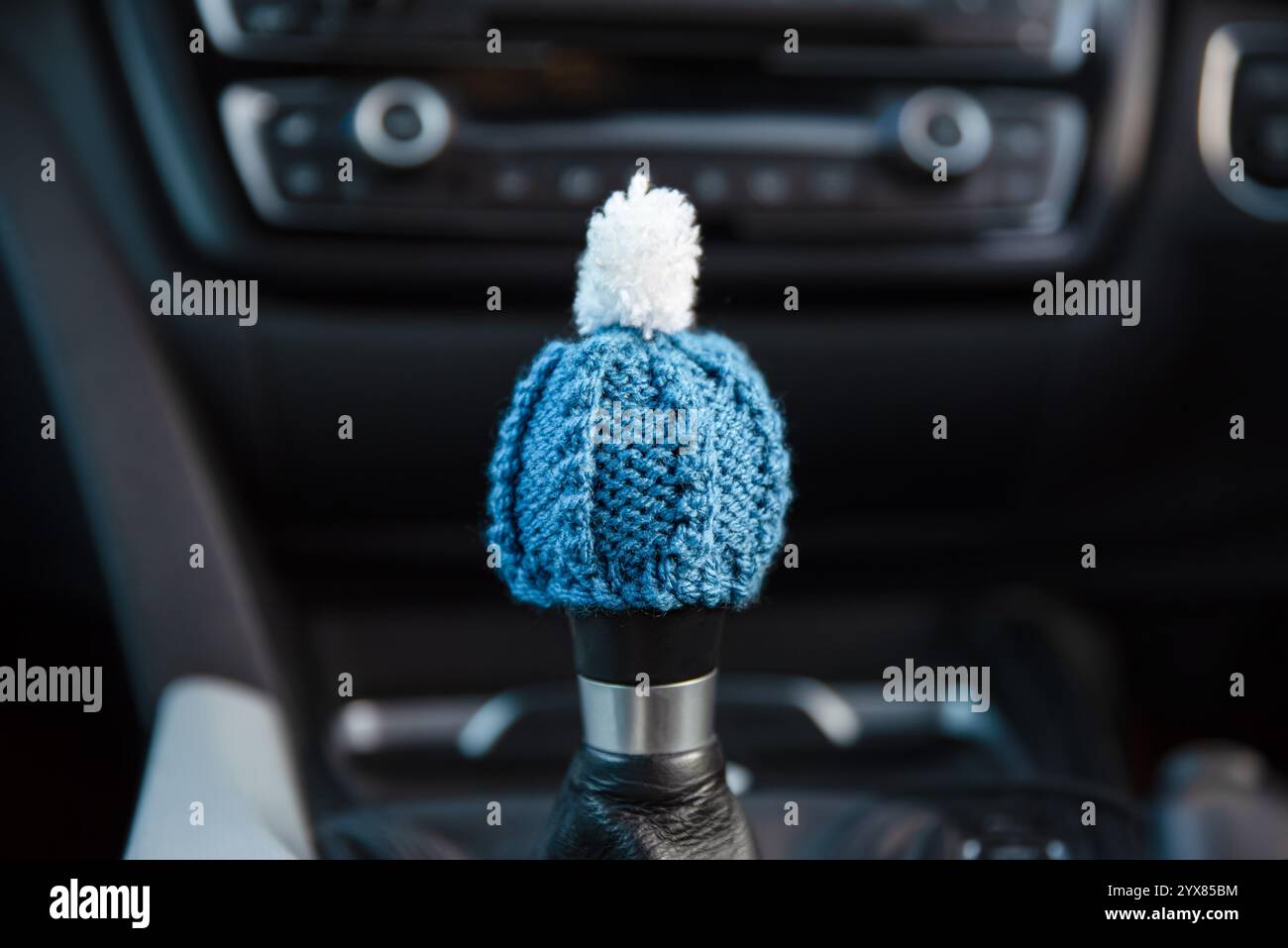 Preparazione della vettura per l'inverno - concetto. Un piccolo cappello in maglia di lana sulla leva del cambio del veicolo. Preparazione invernale del veicolo o guida in inverno Foto Stock