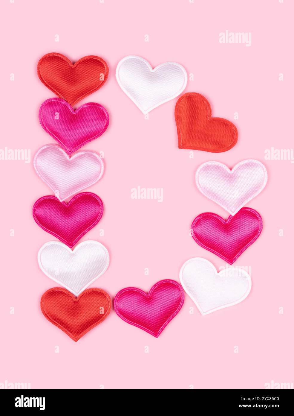 Lettera D realizzata con cuori lucidi dell'atlante isolati su sfondo rosa pieno. Amo il concetto dell'alfabeto. Una lettera del set di font Heart facile da impilare. Foto Stock