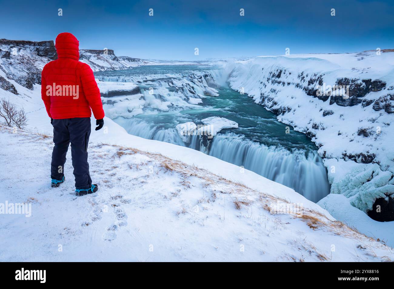 Una persona che ammira le cascate di Gullfoss in inverno all'alba. Hrunamannahreppur, Árnessýsla, Suðurland, Islanda, Nord europa. Foto Stock