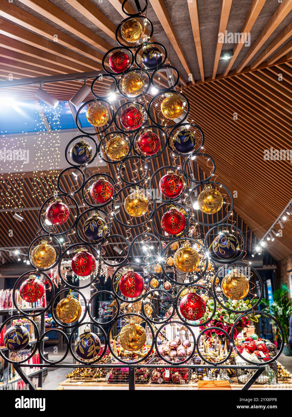 Decorazioni contemporanee a tema albero di Natale baubles decorazioni interne festose appese a baubles colorati negozio agricolo Surrey Regno Unito Foto Stock