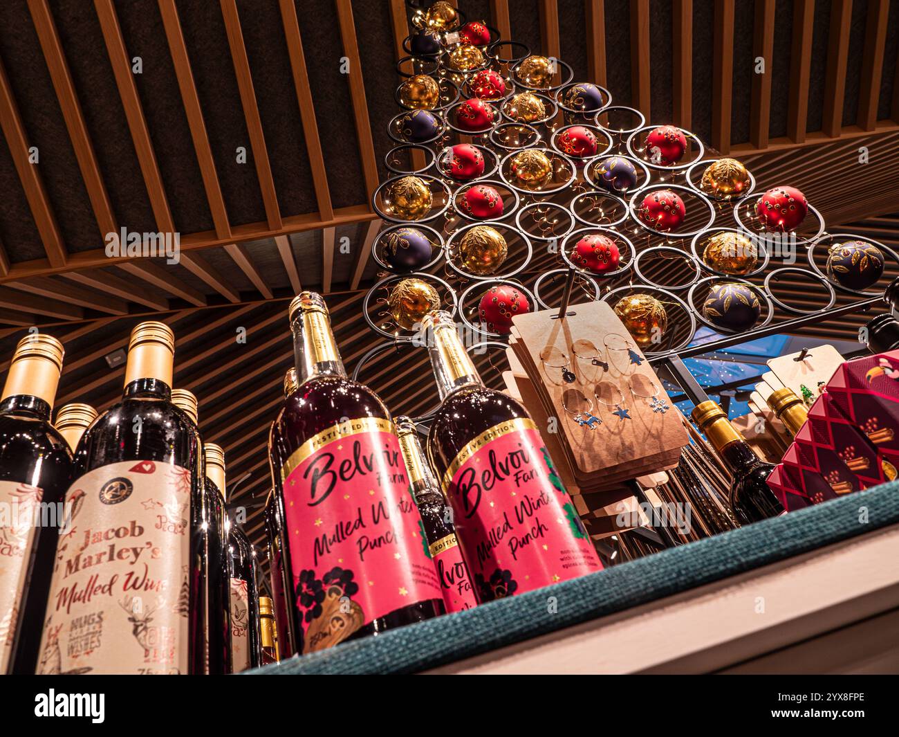 Bottiglie di VIN brulé in vendita con decorazioni a tema sull'albero di Natale, negozio agricolo Surrey UK Foto Stock