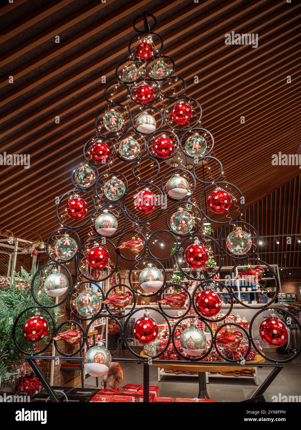 Decorazioni a tema albero di Natale baubles decorazioni interne festose appese a baubles colorati negozio agricolo Surrey UK Foto Stock