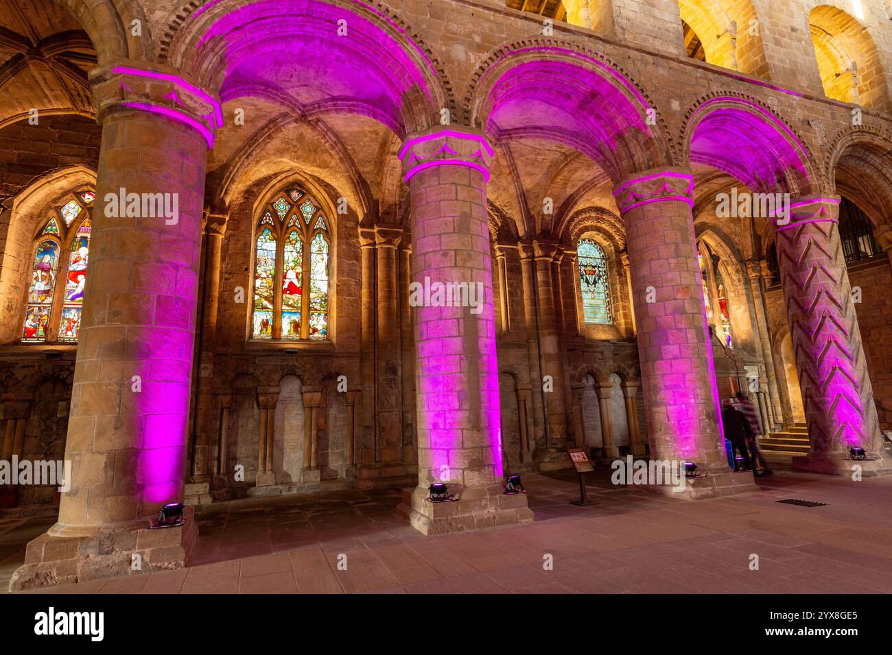 Pilastri e archi nella nave dell'Abbazia di Dunfermline illuminati da luci colorate, Fife, Scozia Foto Stock