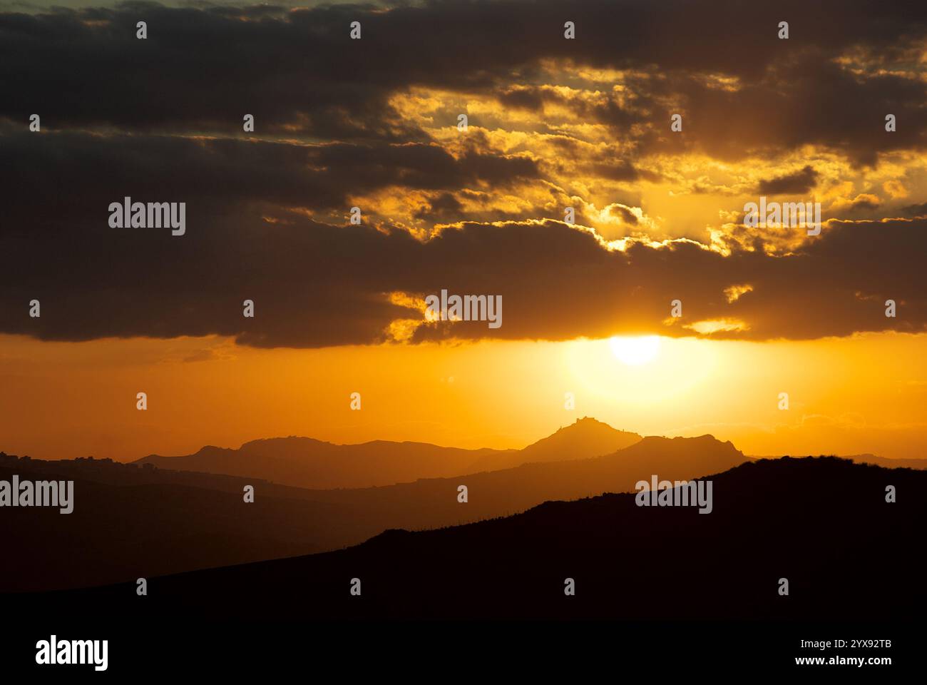 Tramonto arancione sulle colline delle silhouette, Sicilia, Italia Foto Stock