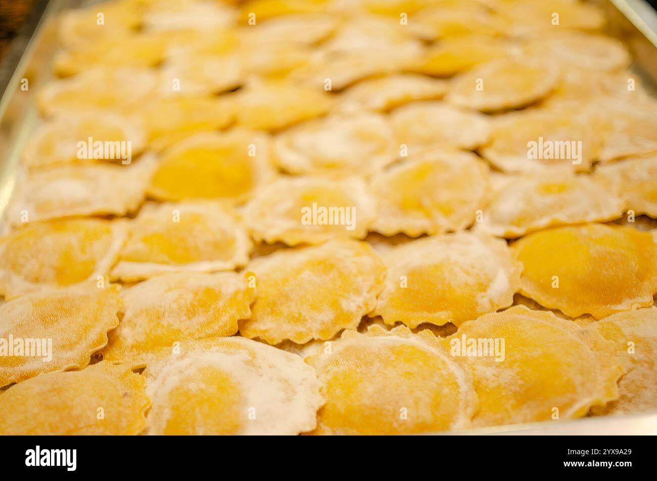 Cremona, Italia - 15 novembre 2020 tortelli freschi con ripieno di torrone, specialità culinaria cremonese, disposti su un vassoio di metallo, pronti Foto Stock
