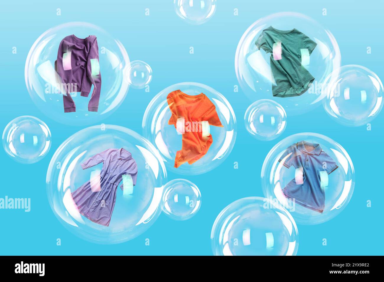 Diverse bolle di sapone con i vestiti all'interno e quelle vuote che fluttuano su sfondo azzurro. Giorno del bucato Foto Stock