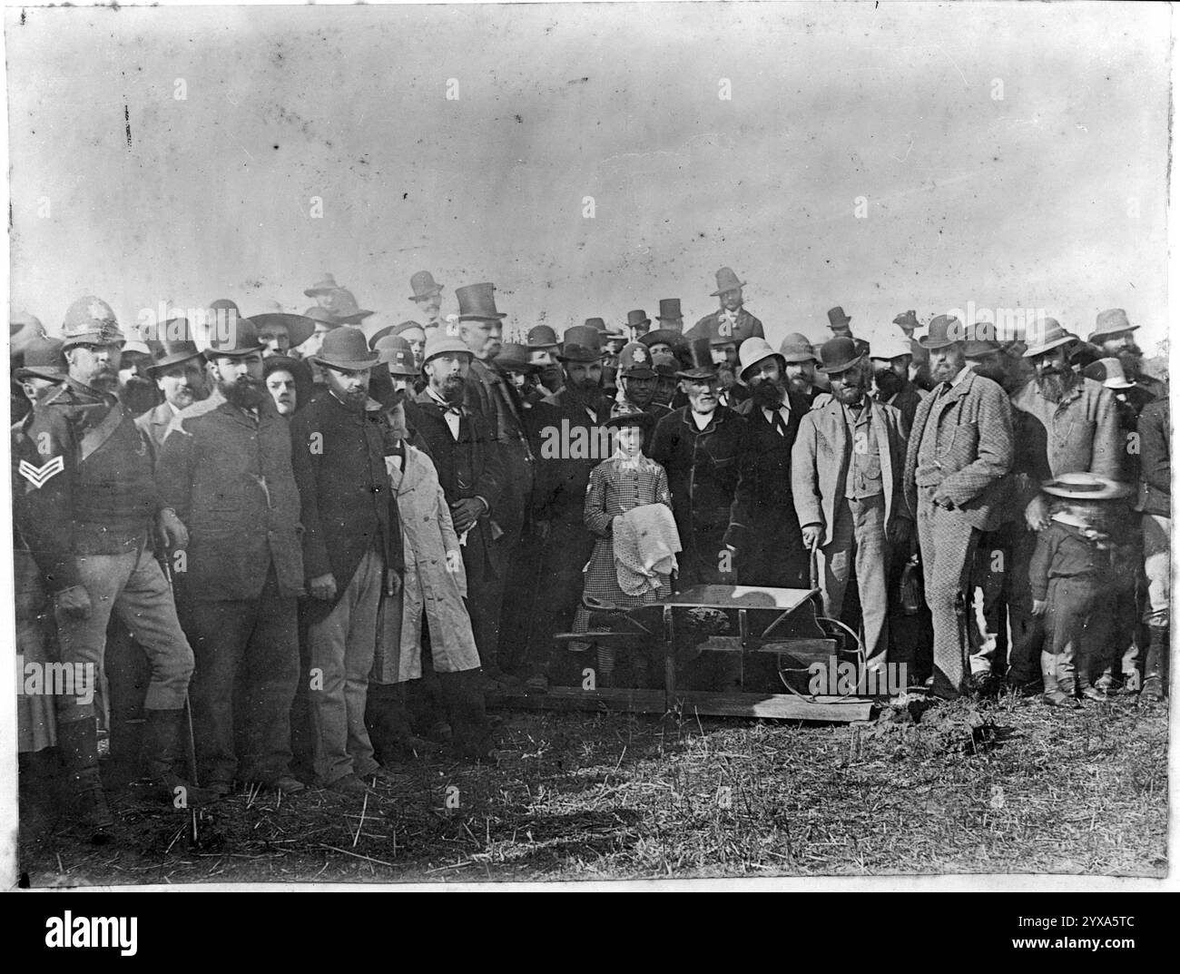 Gruppo allo scavo del primo vascello per la Main Trunk Railway. Si trovarono alla linea di confisca sulla riva meridionale del fiume Puniu, il 15 aprile 1885. Al centro dietro la barrow, con indosso un cappello, c'è Rewi Maniapoto. Subito alla sua sinistra c'è sua figlia, te Kore. Alla sua sinistra e dietro c'è Sir Robert Stout. L'uomo alto che indossa un cappello, in piedi a sinistra di Stout, è Wahanui Huatare. La fotografia originale è stata scattata da Daniel Manders Beere Foto Stock