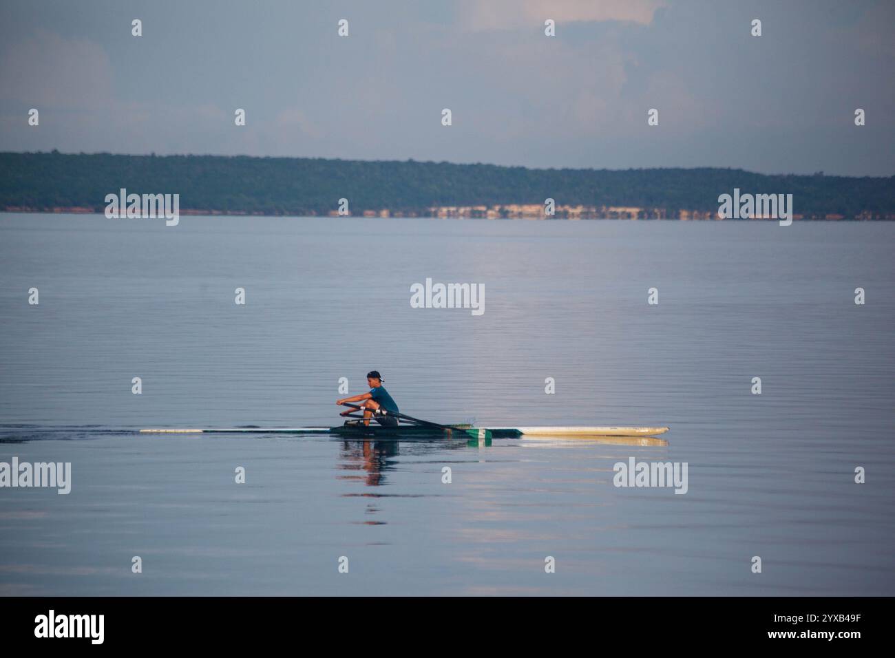 Un solitario Rower che canta la mattina presto a Bahia de Cienfuegos, Cuba Foto Stock