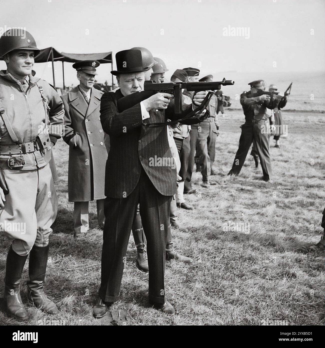 Winston Churchill spara una mitragliatrice Thompson insieme al Comandante Supremo alleato, il generale Dwight D Eisenhower, durante un'ispezione delle forze d'invasione statunitensi, nel marzo 1944 Foto Stock