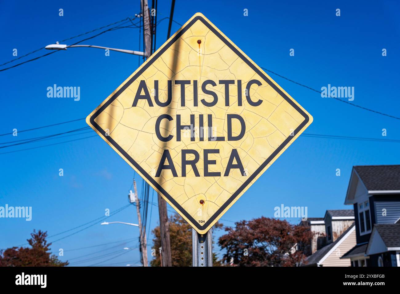 Harbor Isle, New York, Stati Uniti d'America – 23 ottobre 2024: Primo piano di un cartello giallo a forma di diamante con la scritta Autistic Child area. Foto Stock