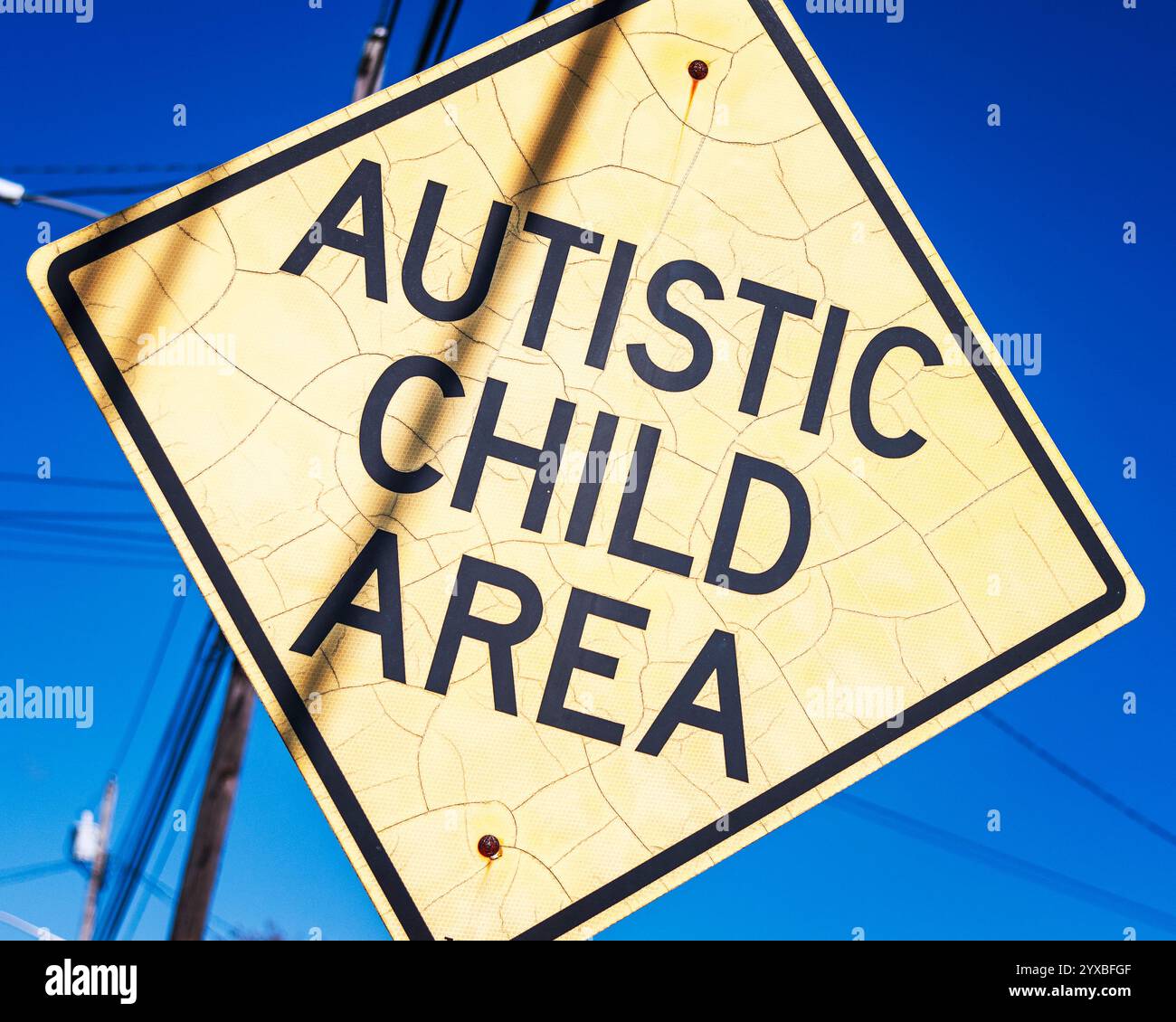 Harbor Isle, New York, Stati Uniti d'America – 23 ottobre 2024: Primo piano di un cartello giallo a forma di diamante con la scritta Autistic Child area. Foto Stock
