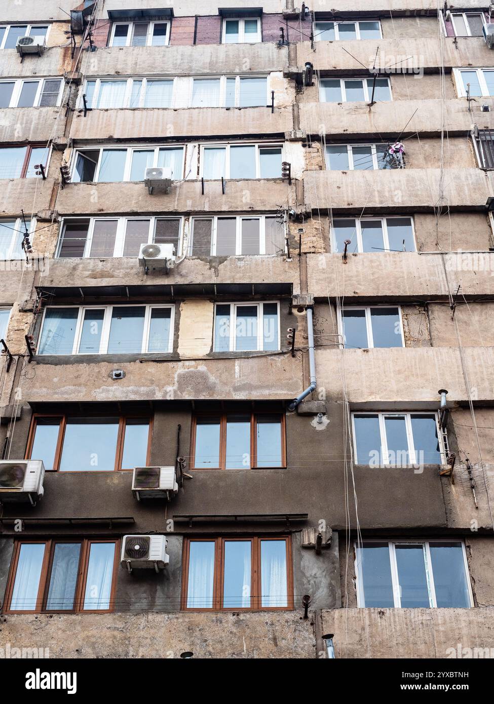 Vista dal basso della facciata della vecchia e alta casa in cemento nella città di Yerevan Foto Stock