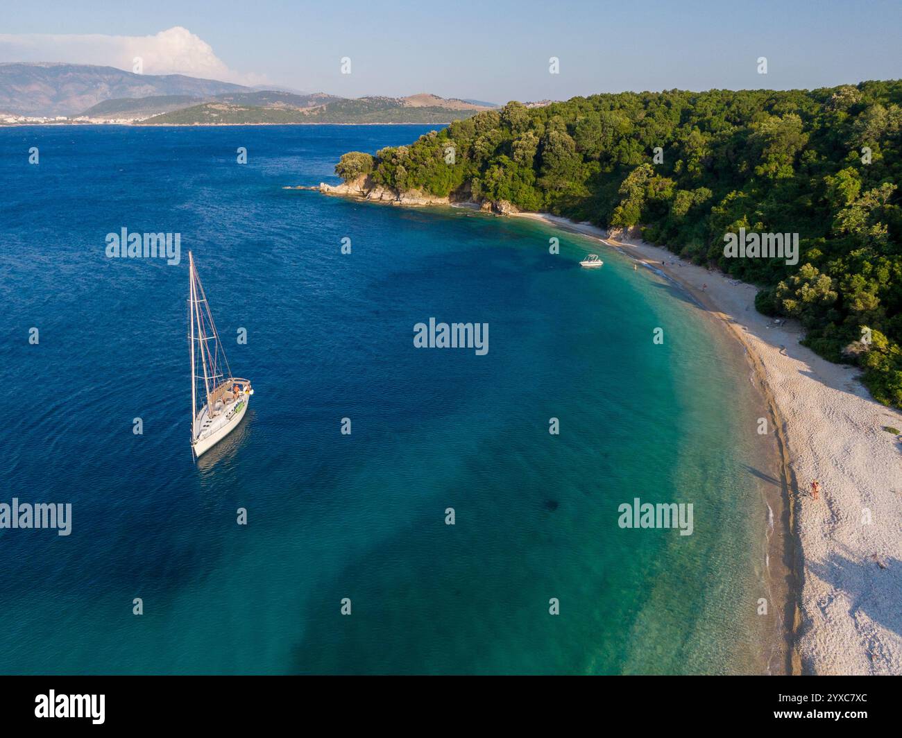 Barca a vela ancorata vicino a una spiaggia pittoresca con acque turchesi. Foto Stock