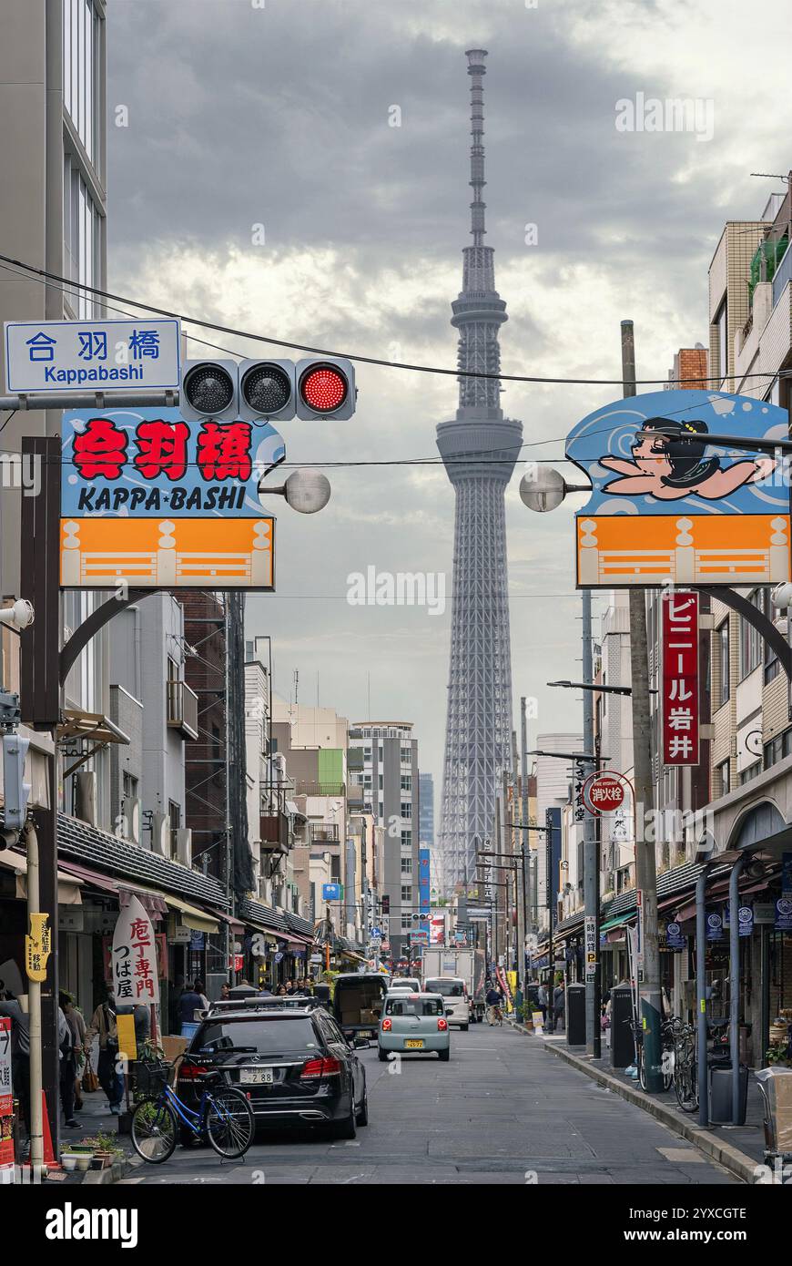 tokyo, taitō - aprile 30 2024: Via Kappabashi-dori conosciuta per i suoi negozi di stoviglie con l'alta torre Tokyo Skytree che presenta una vibrante segnaletica. Foto Stock
