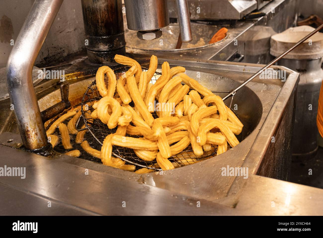 Primo piano di un venditore che frigge churros al suo banco di vendita Foto Stock