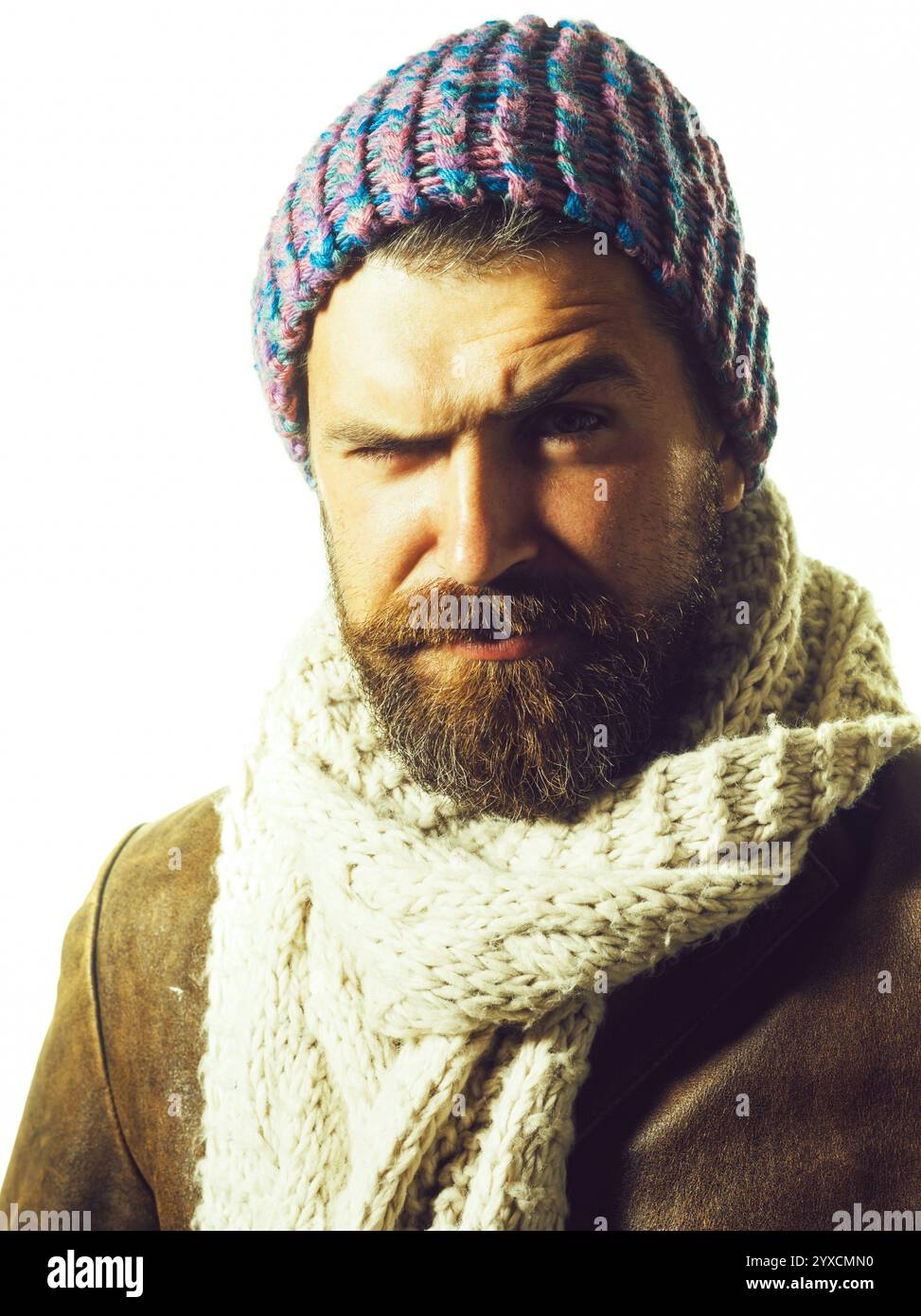 Ritratto ravvicinato di un uomo barbuto alla moda con cappello caldo, sciarpa e giacca in pelle. Bel ragazzo elegante con barba e baffi in abiti semistagionali Foto Stock