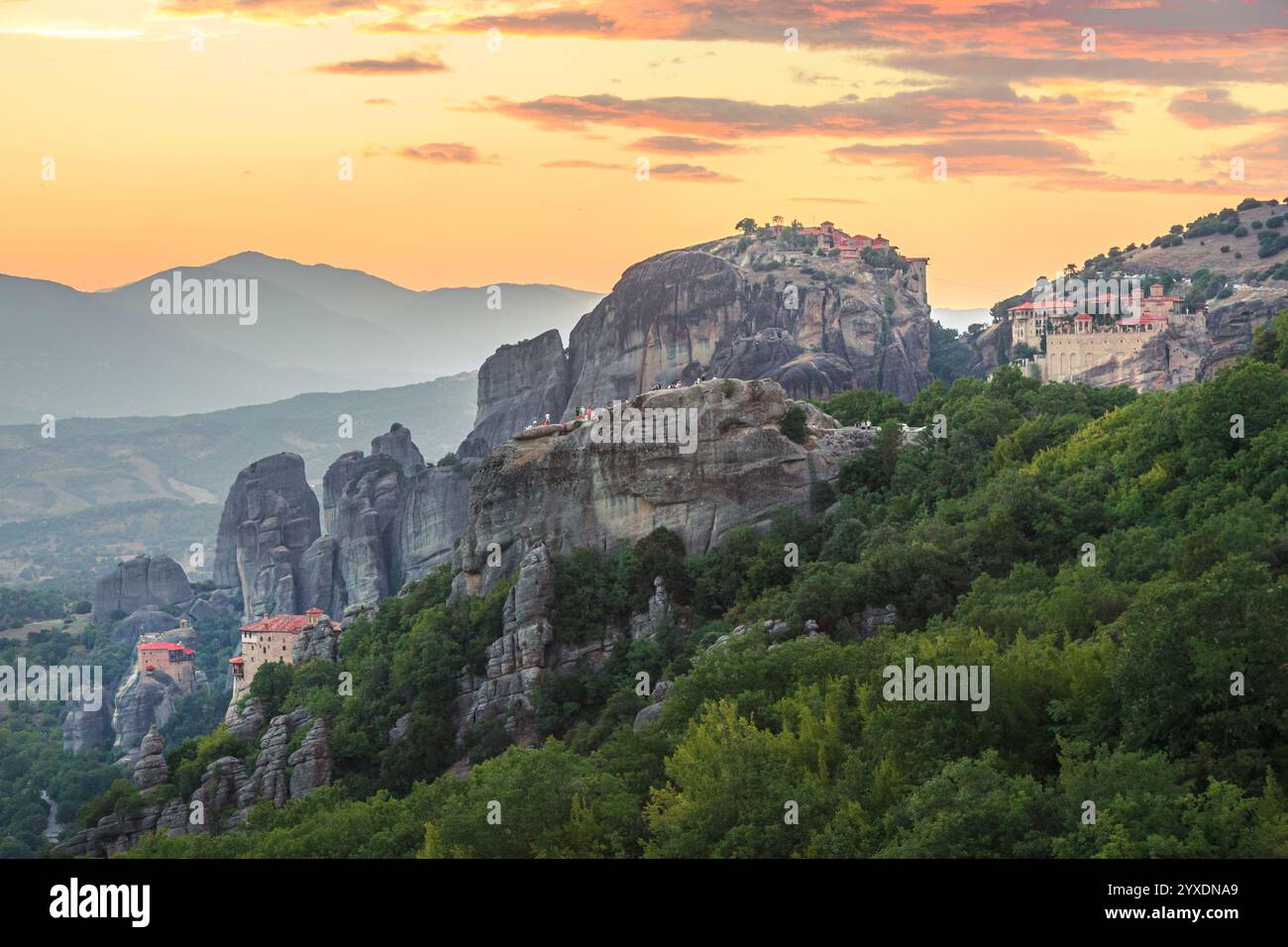Monasteri arroccati su formazioni rocciose al tramonto a Meteora Foto Stock