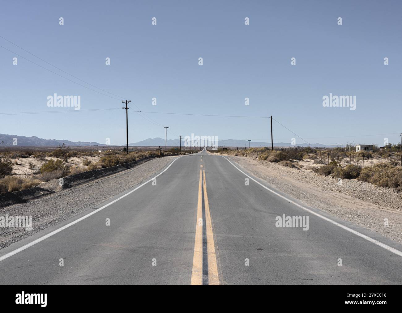 Una strada solitaria che si estende all'infinito attraverso la Palms Wonder Valley della California del 29 Foto Stock