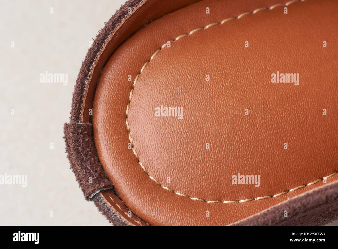 primo piano di sandali da donna in pelle marrone rossastro con grana e texture naturali e linee di cuciture lungo il bordo, lavorazione artigianale del prodotto in pelle Foto Stock