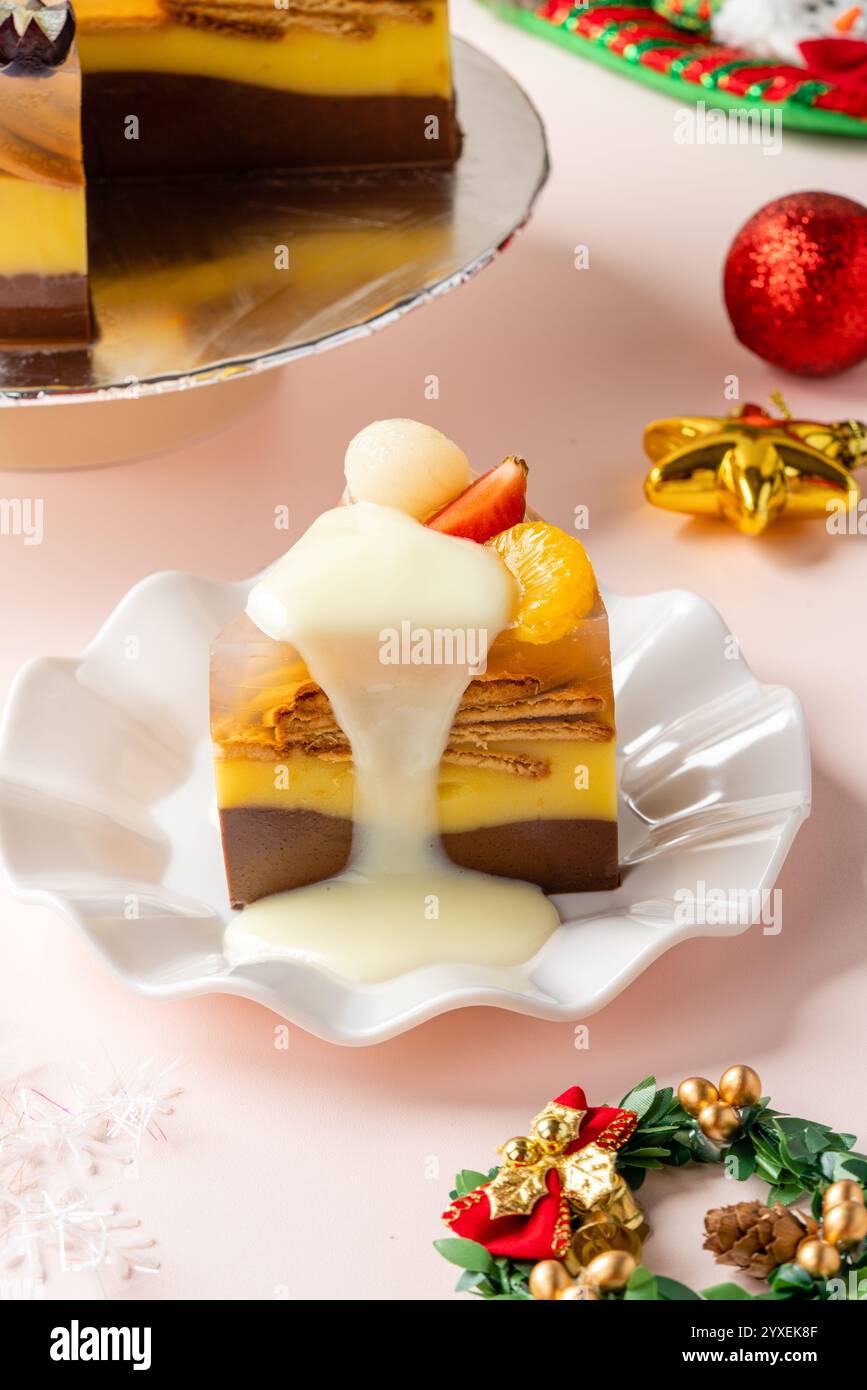 Budino di frutta fatto in casa con fragole, uva, arancia, longan, kiwi e pesca, decorato con decorazioni natalizie Foto Stock