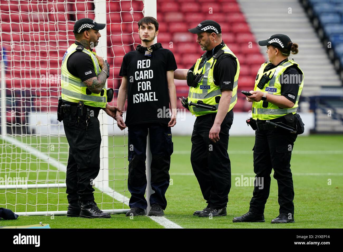 RECENSIONE PA DELL'ANNO 2024 foto del file datata 31/05/24: La polizia parla con una protesta che indossa una maglietta "Red Card for Israel" dopo essersi incatenata a un punto di arrivo davanti alla partita di qualificazione UEFA Euro 2025 di Lega B, gruppo B2 a Hampden Park, Glasgow. Data di pubblicazione: Lunedì 16 dicembre 2024. Foto Stock