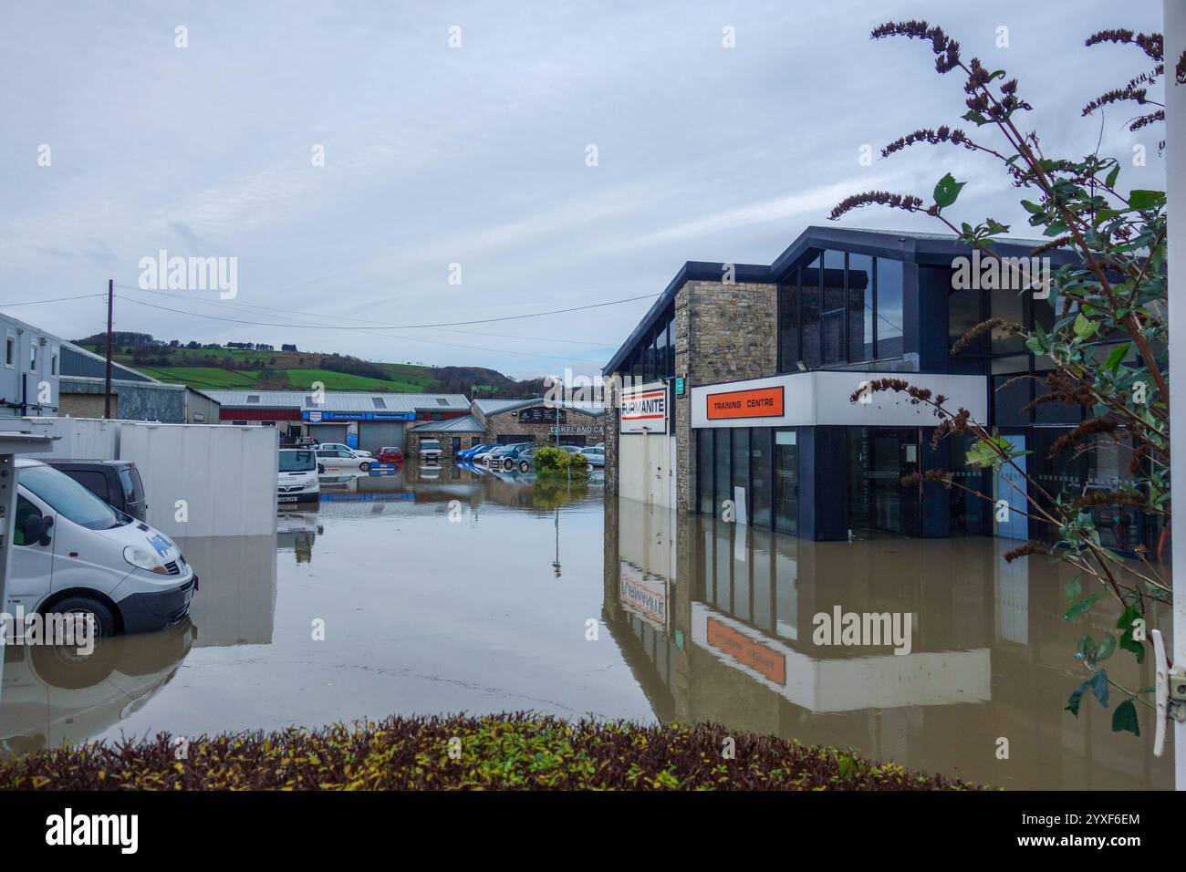 I locali commerciali e il parcheggio sono stati inondati dalla tempesta Desmond, che ha mostrato gli effetti della devastante tempesta che ha causato il caos in tutta la Cumbria. Foto Stock