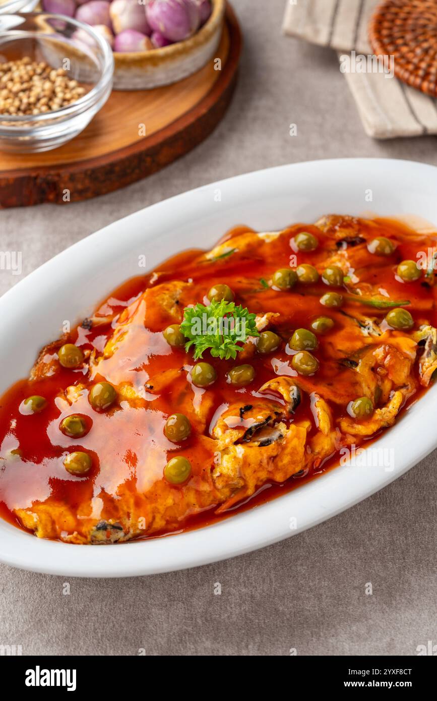 Fu yung hai, Puyonghai o egg foo Young, un famoso piatto di emelette in stile cinese in Indonesia. a base di uova, verdure e salsa Foto Stock