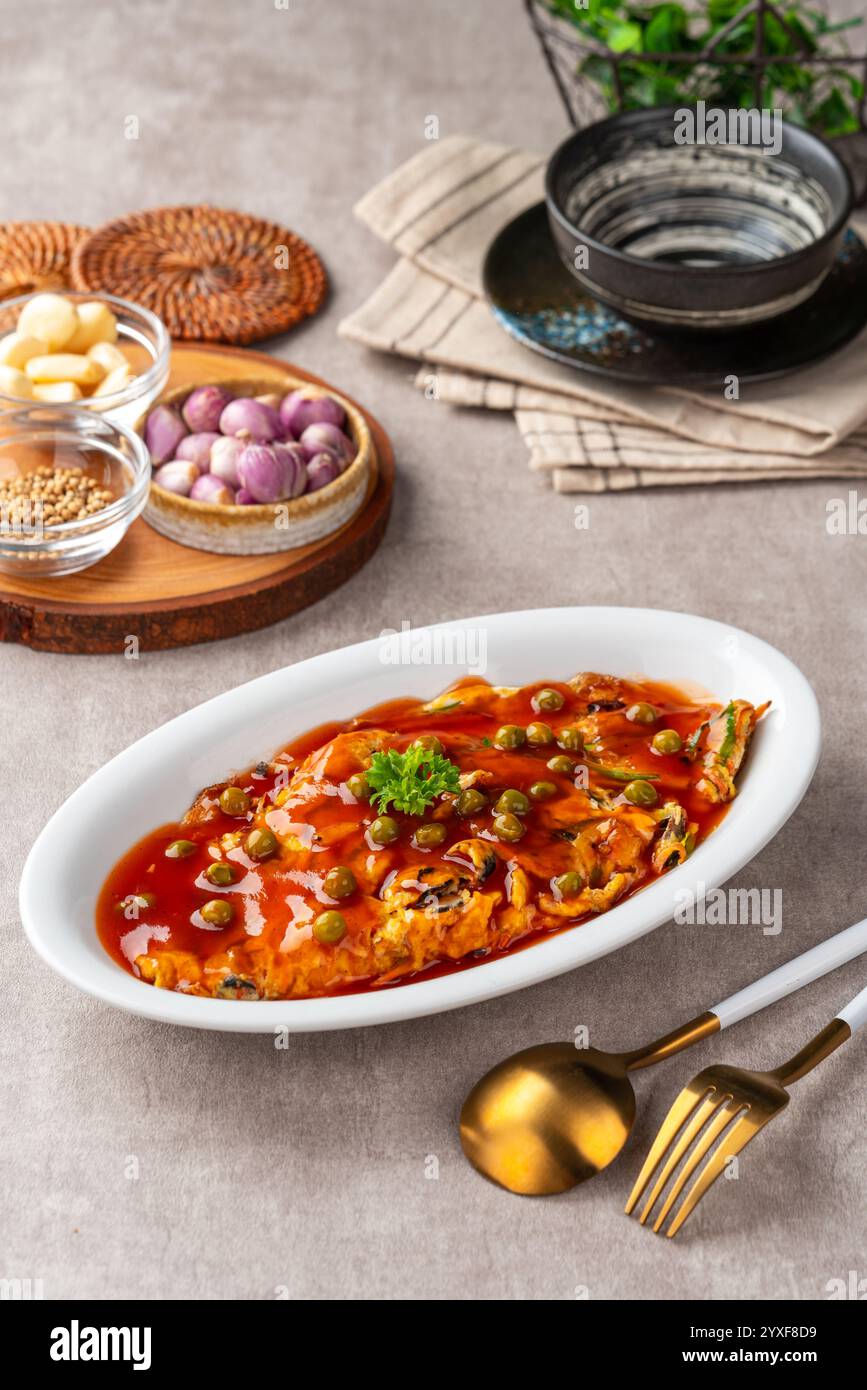 Fu yung hai, Puyonghai o egg foo Young, un famoso piatto di emelette in stile cinese in Indonesia. a base di uova, verdure e salsa Foto Stock