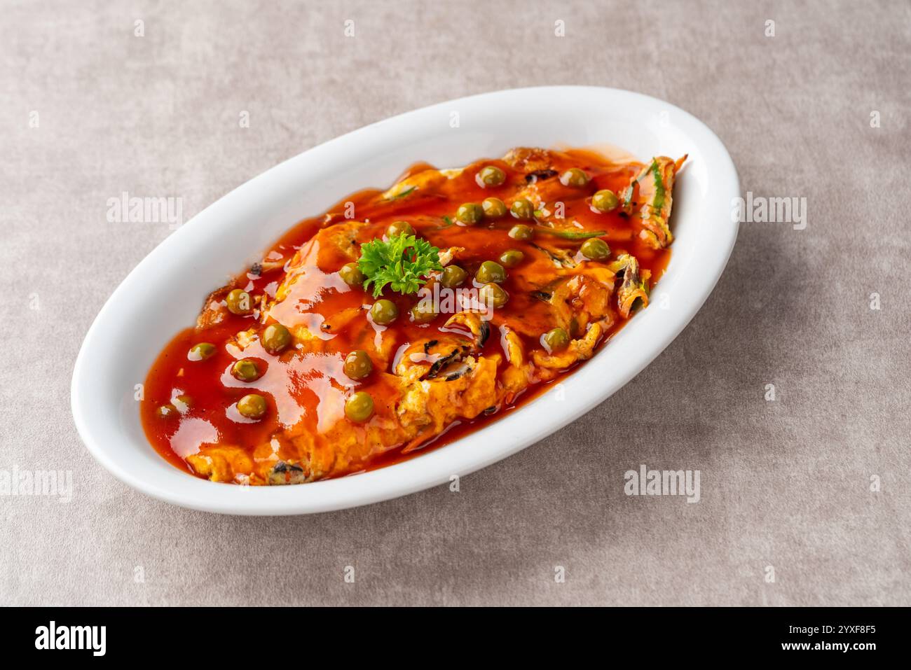 Fu yung hai, Puyonghai o egg foo Young, un famoso piatto di emelette in stile cinese in Indonesia. a base di uova, verdure e salsa Foto Stock