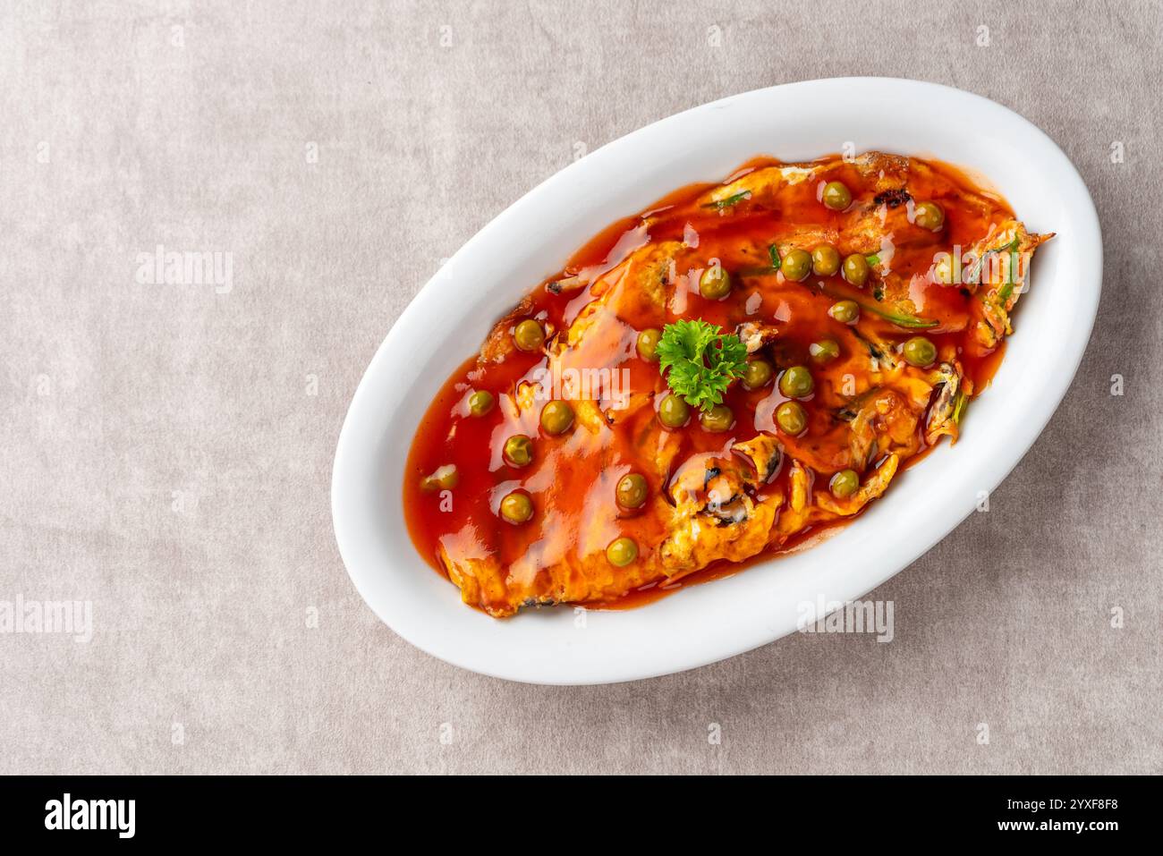 Fu yung hai, Puyonghai o egg foo Young, un famoso piatto di emelette in stile cinese in Indonesia. a base di uova, verdure e salsa Foto Stock