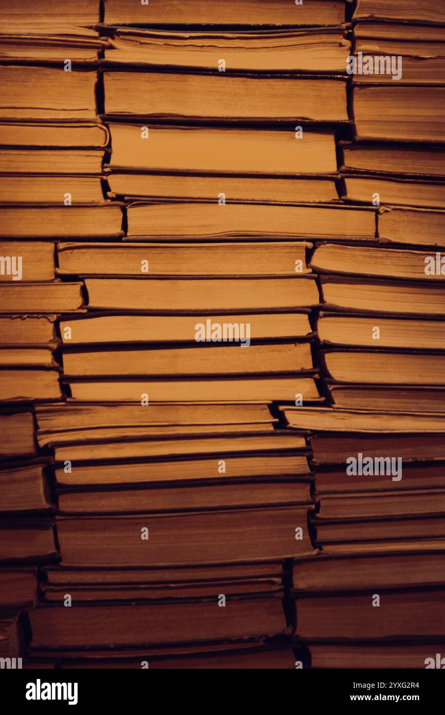 Sfondo antico da libreria con luce calda. Un mucchio di vecchi libri. Archiviazione. Hobby di lettura. Libreria libreria. Concetto di letteratura. Foto Stock