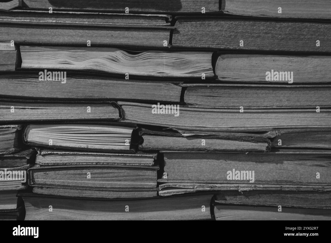 Sfondo libreria antica, bianco e nero. Una pila di vecchi libri, monocromatici. Archiviazione. Hobby di lettura. Libreria libreria. Concetto di letteratura. Foto Stock