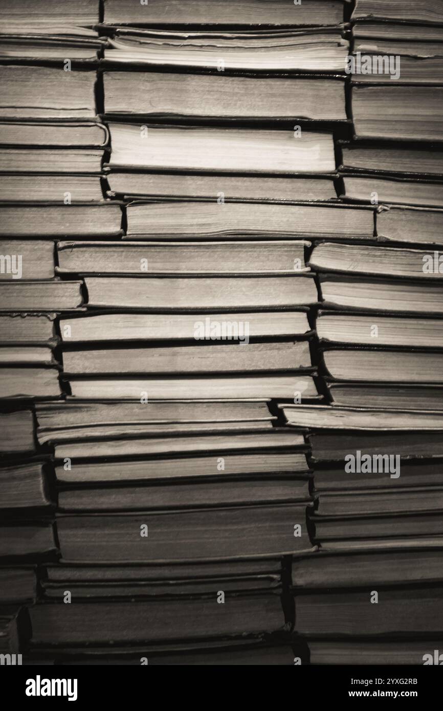 Sfondo libreria antica, bianco e nero. Una pila di vecchi libri, monocromatici. Archiviazione. Hobby di lettura. Libreria libreria. Concetto di letteratura. Foto Stock