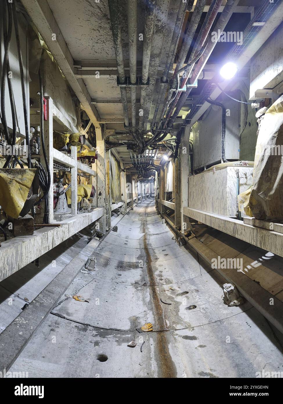 Lungo tunnel industriale con cavi esposti e illuminazione soffusa Foto Stock