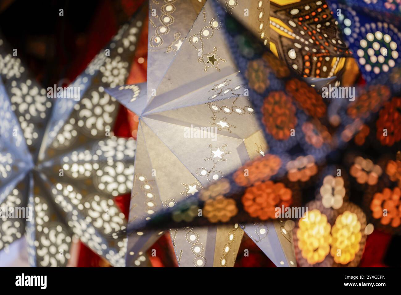 Stelle di carta colorate con motivi a vista e retroilluminazione in un mercatino di Natale, Colonia, Renania settentrionale-Vestfalia, Germania, Europa Foto Stock