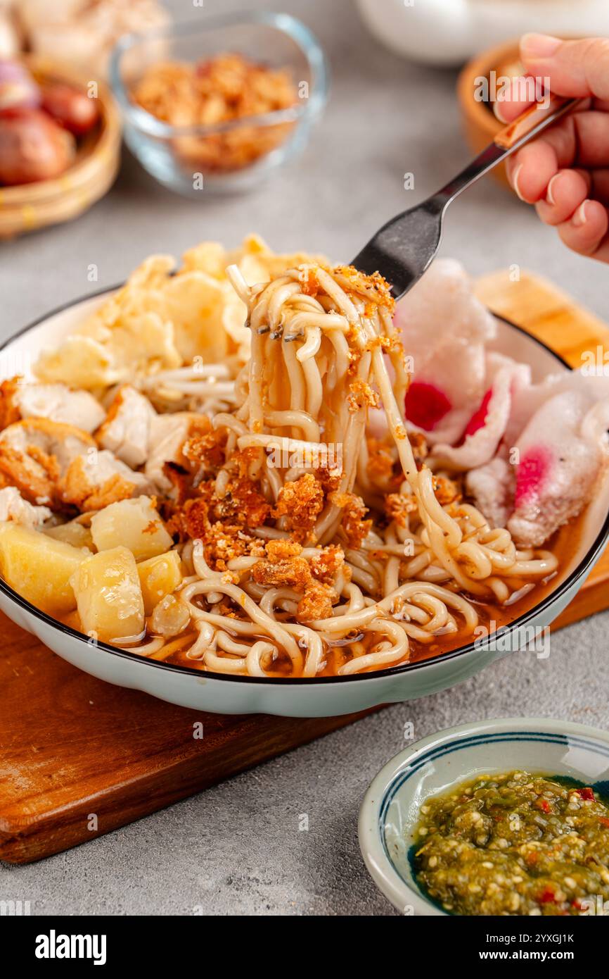 Emie, mie rebus è una zuppa di spaghetti composta da brodo di gamberi, uova sode e patate, gamberi secchi, cipolla fritta e foglia di cipolla. Foto Stock