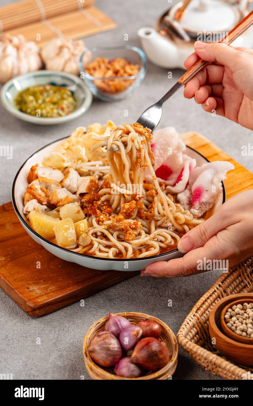 Emie, mie rebus è una zuppa di spaghetti composta da brodo di gamberi, uova sode e patate, gamberi secchi, cipolla fritta e foglia di cipolla. Foto Stock