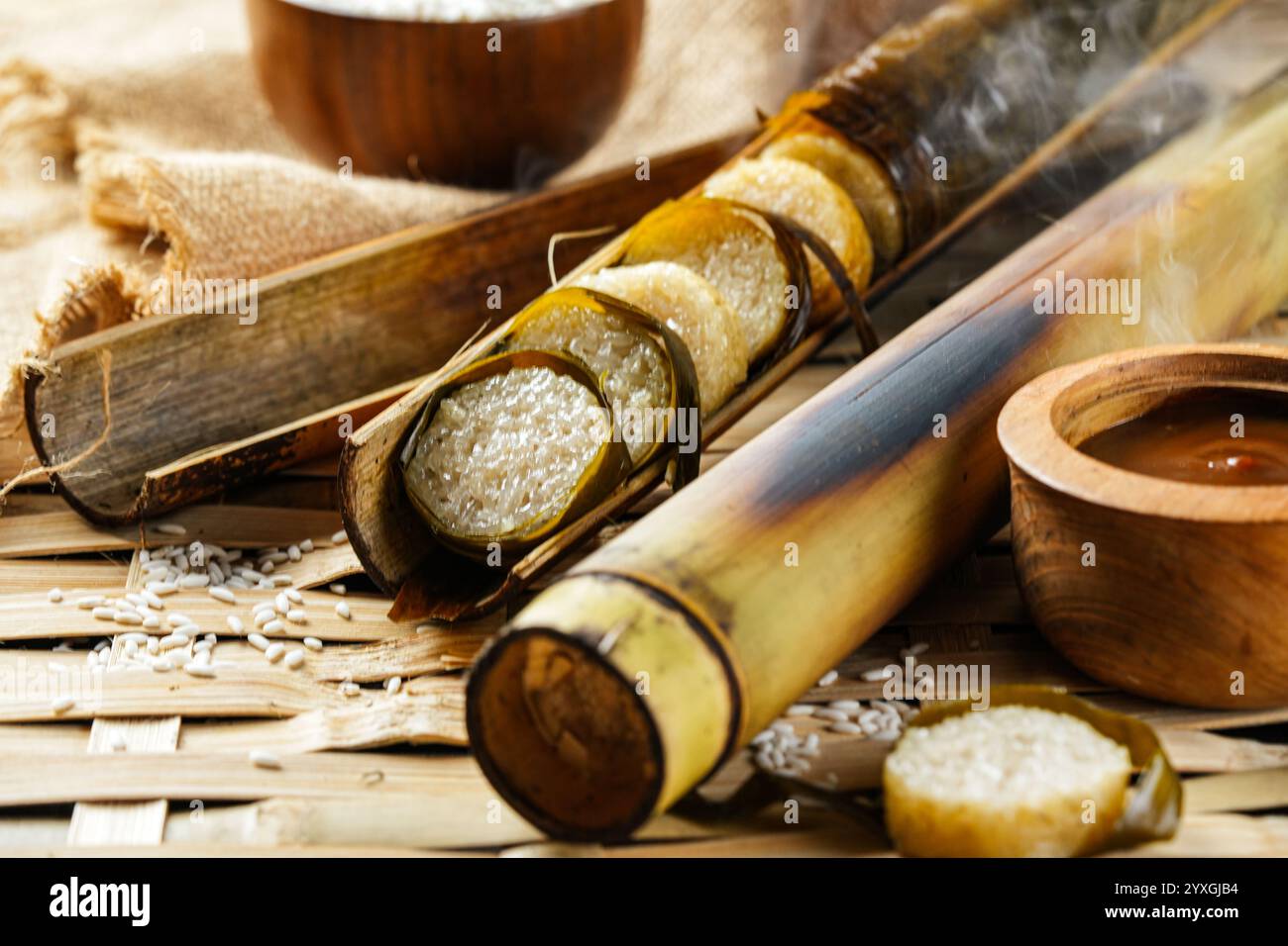 Lemang. Il riso glutinoso viene avvolto con foglie di lerek o di banana racchiuse in culme di bambù e cucinate a fuoco aperto. Foto Stock