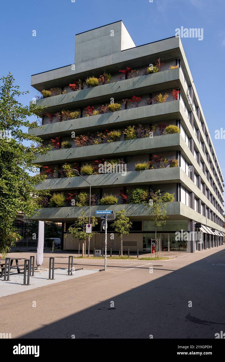 Edificio a piu' piani con piante e cespugli Foto Stock