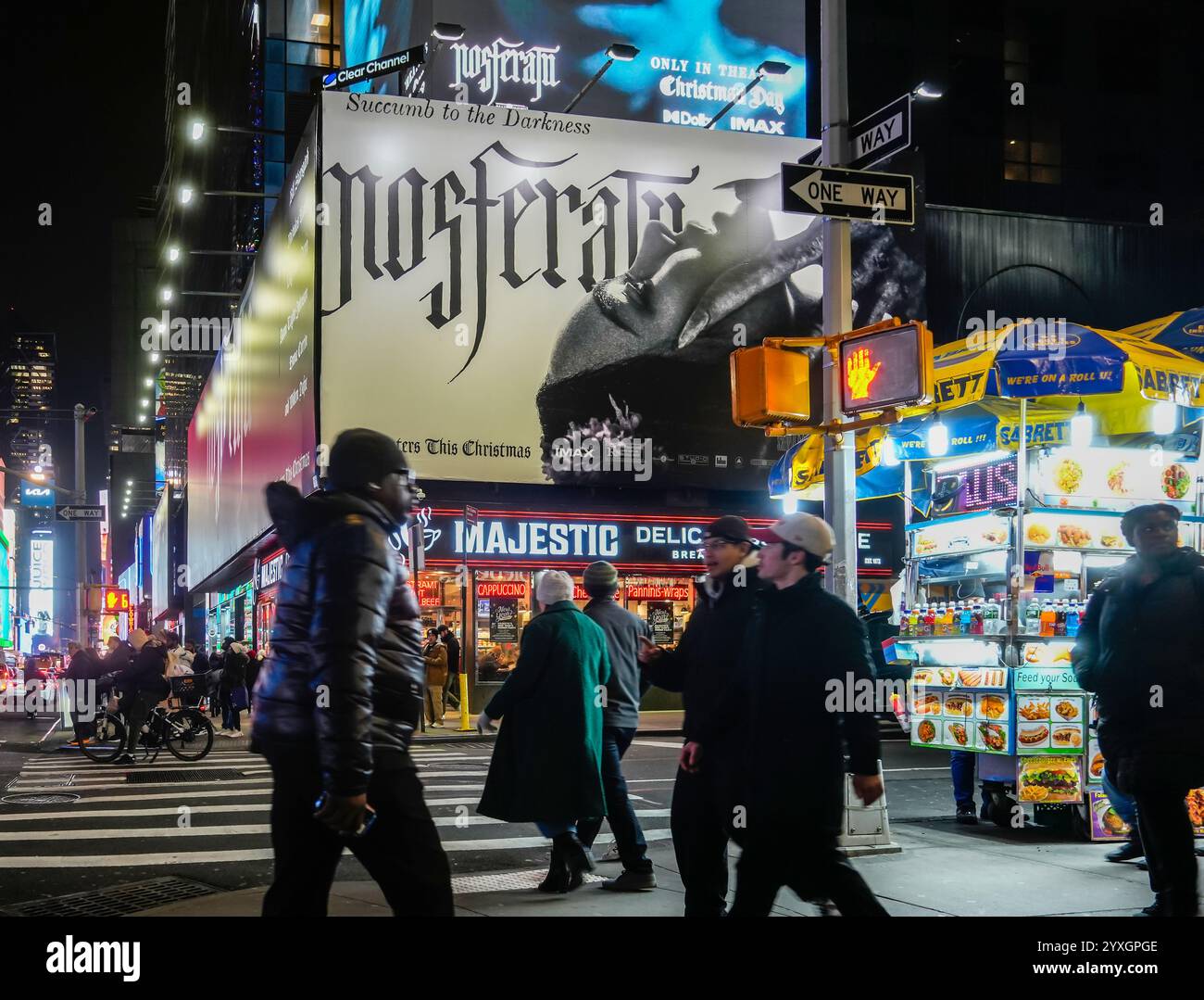 I visitatori di Times Square a New York mercoledì 4 dicembre 2024 camminano sotto una pubblicità per il film ÒNosferatuÓ, un remake del film muto del 1922 e saranno pubblicati negli Stati Uniti il giorno di Natale. (© Richard B. Levine) Foto Stock